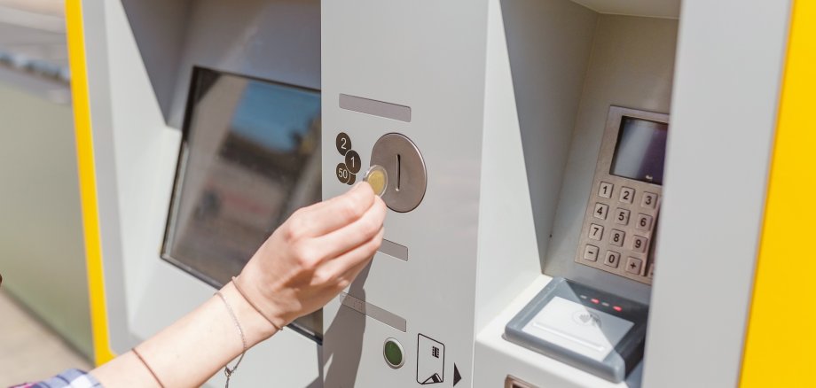 young woman paying at ticket machine in a public transport station