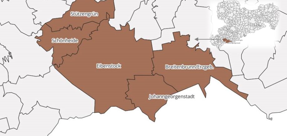 Zu sehen ist eine Landschaftsaufnahme der Kommune Breitenbrunn im Erzgebirge. Die Landschaft ist hügelig und verschneit. In der verschneiten Landschaft stehen mehrere Baumgruppen, der Himmel ist klar und blau. 